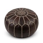 A dark brown leather round pouf with traditional geometric stitching, isolated on a clean white background.