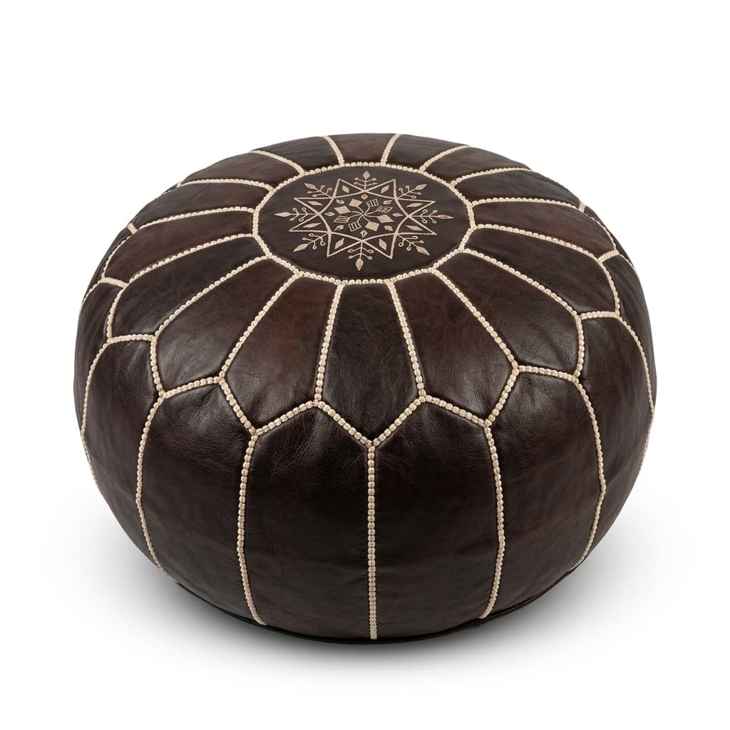 dark-brown-leather-round-pouf-white-background-studio A dark brown leather round pouf with traditional geometric stitching, isolated on a clean white background.