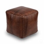 A studio product shot of a dark brown square leather ottoman isolated on a clean white background.