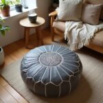 Handcrafted gray leather round ottoman with white embroidered star pattern in cozy Scandinavian interior