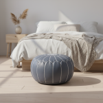 Leather Pouf Gray styled in a minimalist bedroom with white bedding and wooden furniture.