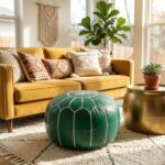 A vibrant living room setting featuring a green leather floor ottoman placed on a cream rug in front of a mustard yellow velvet sofa.