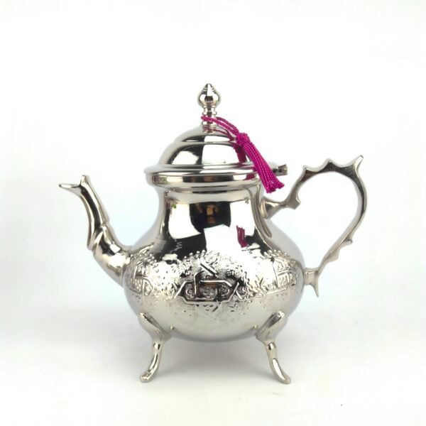 Contemporary luxury Moroccan Silver Teapot 1.5L Engraved by hand with intricate geometric motifs, featuring a highly polished finish and a traditional pink tassel on a pure white background.