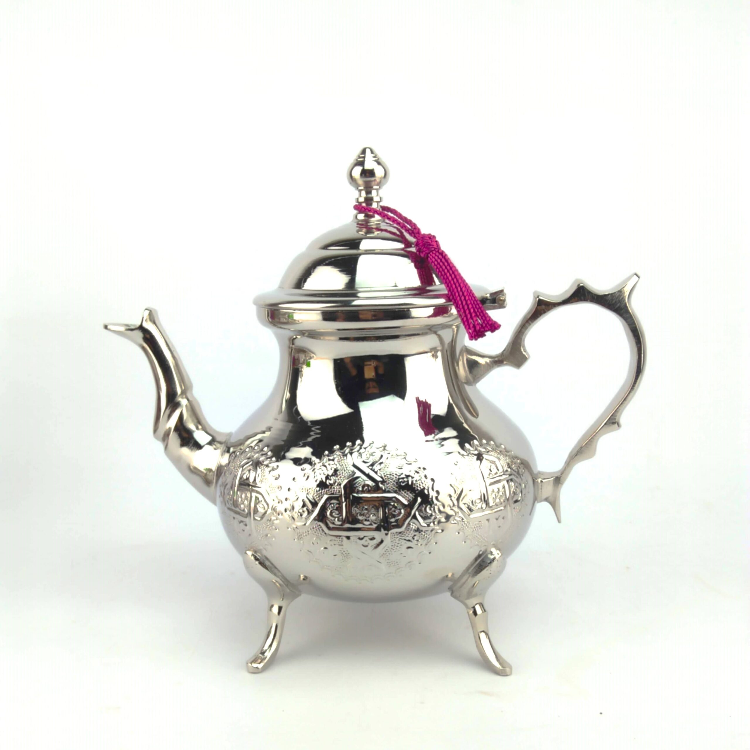 silver-teapot-1-5l-engraved-moroccan-handmade. (1) Contemporary luxury Moroccan Silver Teapot 1.5L Engraved by hand with intricate geometric motifs, featuring a highly polished finish and a traditional pink tassel on a pure white background.