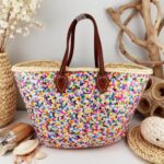 Multicolor Sequin Straw Bag on wooden shelf with natural straw rim and brown leather handles