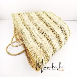 Model wearing natural striped straw basket bag with summer dress