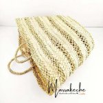 Handwoven straw basket bag tilted angle showing lattice pattern weave and woven handles closeup