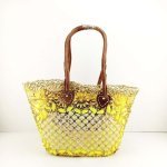 Embroidered straw tote bag with yellow sunflower embellishments and brown leather handles, front view