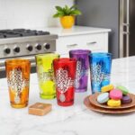 Blue and red hamsa hand tea glasses with silver metal filigree on tiled kitchen counter