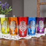 Purple and amber hamsa hand tea glasses with silver wire-wrapped filigree on white lace