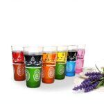Close-up of hand-painted moroccan tea glasses showing white spiral and floral henna-style patterns on colored glass