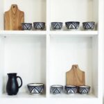 Four ceramic serving bowls with traditional Zwak patterns arranged in row on dark surface