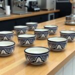 Hand-painted ceramic serving bowls with traditional Zwak patterns arranged on kitchen counter