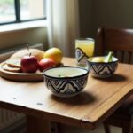 Traditional ceramic serving bowl with geometric black patterns on breakfast table with juice
