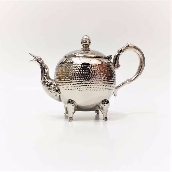 Classic hammered silver teapot on white background