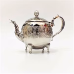 Silver-plated royal tea pot with traditional design on white background
