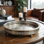 Silver tray with feet on wooden coffee table with candles highlighting geometric mandala engraving