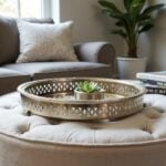 Silver tray with feet displaying small succulent on Moroccan pouf ottoman as decorative accent