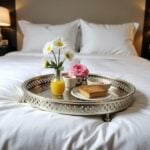 Silver tray with feet serving breakfast in bed with fresh flowers and coffee cup