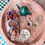 Green enameled teapot with traditional Moroccan tea service setting