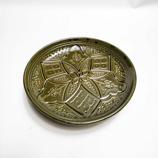 Pink geometric ceramic plate elegant restaurant setting with wine glass, hand-engraved artisan design