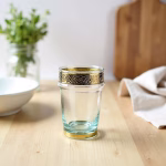 Single clear Moroccan tea glass showing gold metal detail