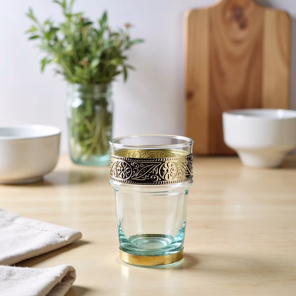 Clear tea glasses with gold metal bands on wooden table