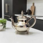 Silver-plated engraved teapot 6-cup with floral band on a marble kitchen countertop