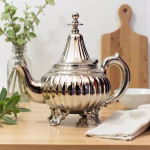 Elegant footed silver teapot displayed in modern kitchen setting