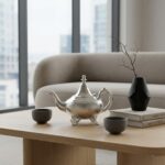 Hammered silver teapot footed traditional on a light oak coffee table in a bright minimalist living room
