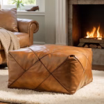 Modern square pouf in light brown leather by fireplace