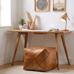 Square leather pouf as desk footrest in workspace