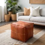Tan square leather ottoman styled in modern living room with beige sofa and natural decor