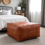 Dark brown square leather ottoman in traditional living room with white cabinet and plants