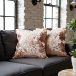 Embroidered cotton pillow covers with dimensional floral pattern on charcoal sofa in industrial loft