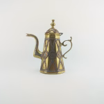 Close-up detail of old copper teapot showing ornate Moroccan calligraphy patterns and aged copper patina finish