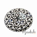 Hand-painted ceramic plates set stacked showing black geometric patterns and dots on white dinnerware