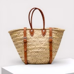 Chevron pattern straw backpack with brown leather straps on white background