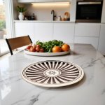 Modern kitchen with brown hand-painted ceramic plate featuring sunburst pattern on marble countertop