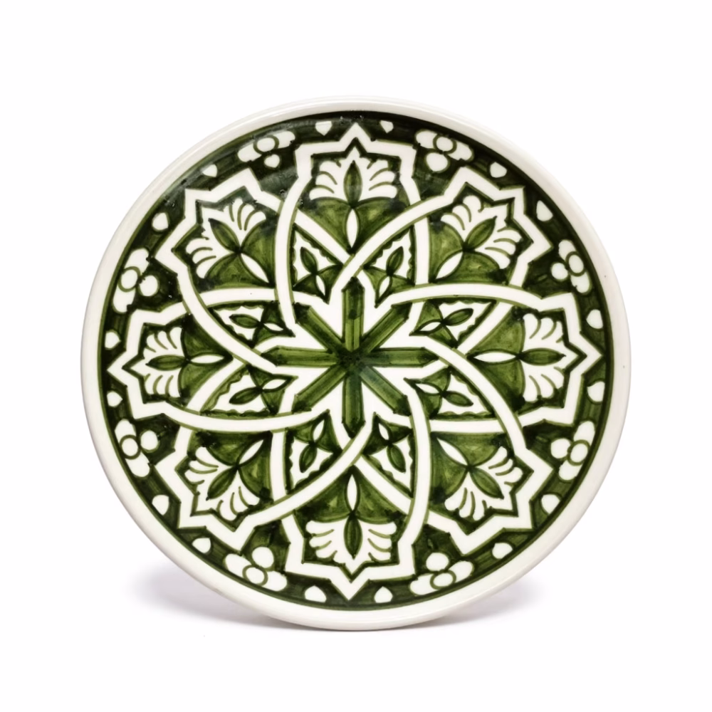 Close-up of green pottery serving dishes showing intricate hand-drawn patterns
