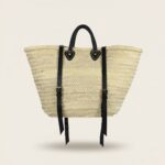Convertible Straw Backpack Tote with black leather backpack straps and brass buckle hardware on an off-white background