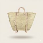 Convertible Straw Backpack Tote with natural leather straps and buckles shown from the back on an off-white background