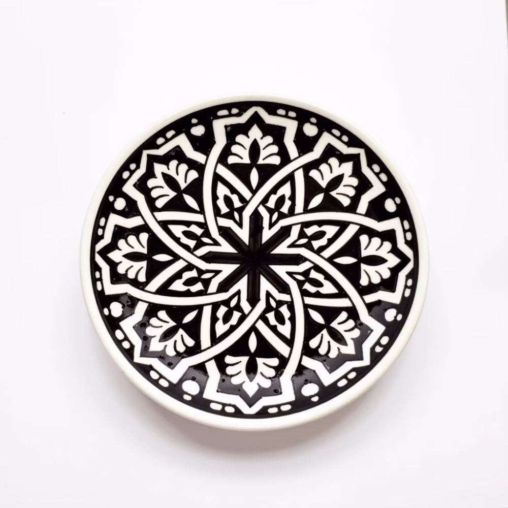 Hand-drawn geometric pattern on black ceramic serving dish with traditional Moroccan motifs