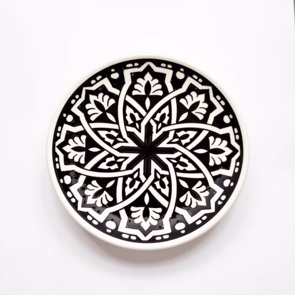 Hand-drawn geometric pattern on black ceramic serving dish with traditional Moroccan motifs