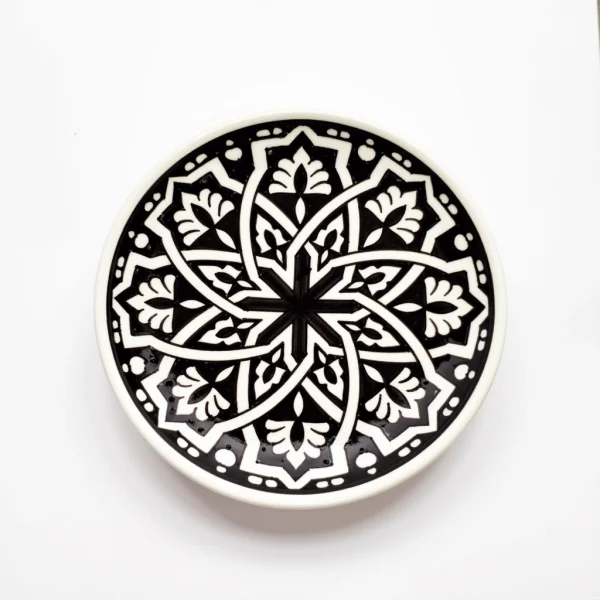 Hand-drawn geometric pattern on black ceramic serving dish with traditional Moroccan motifs