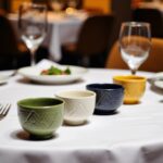 Green geometric ceramic bowl set with textured patterns on glass table in living room