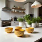 Yellow geometric ceramic bowls arranged on wooden table near bright window