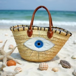 Evil eye beach bag styled with seashells on sandy beach