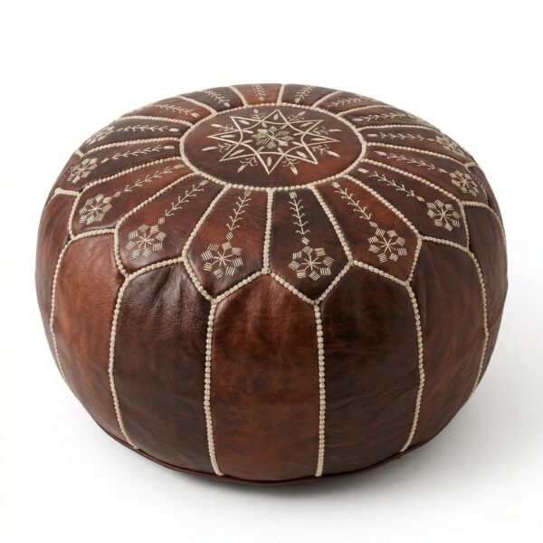 A dark brown leather floor ottoman featuring intricate white embroidered geometric patterns, isolated against a solid white background.
