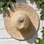 Top view handwoven straw hat showing spiral weave pattern and wide brim, natural beige color